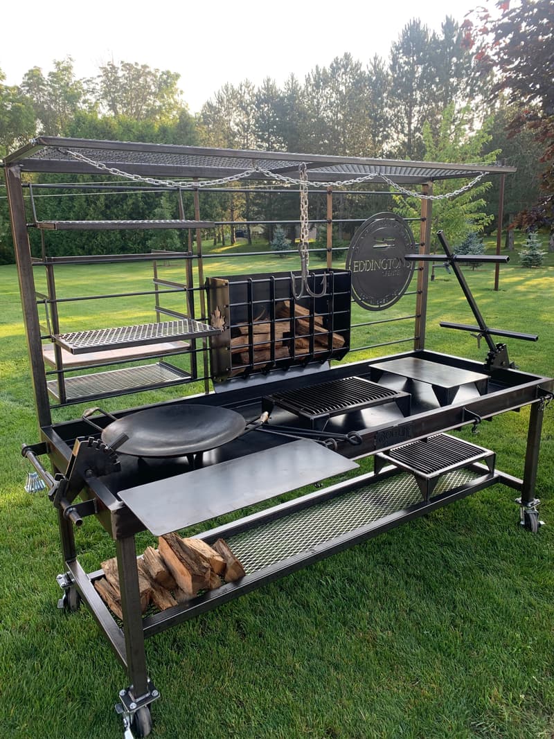 Bog Line live-fire rig with adjustable hanging grates and a wood cradle, set up on a lawn